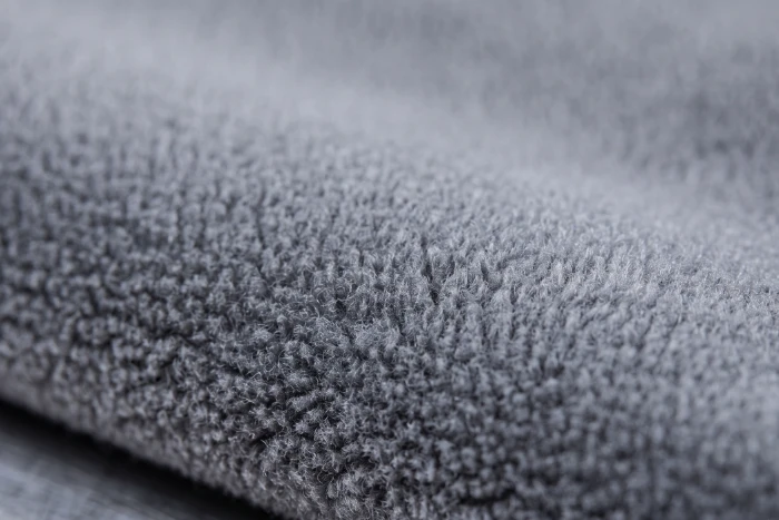 lawlessly dyed medium-grey polyester microfiber polar fleece fabric highlighting even color.
